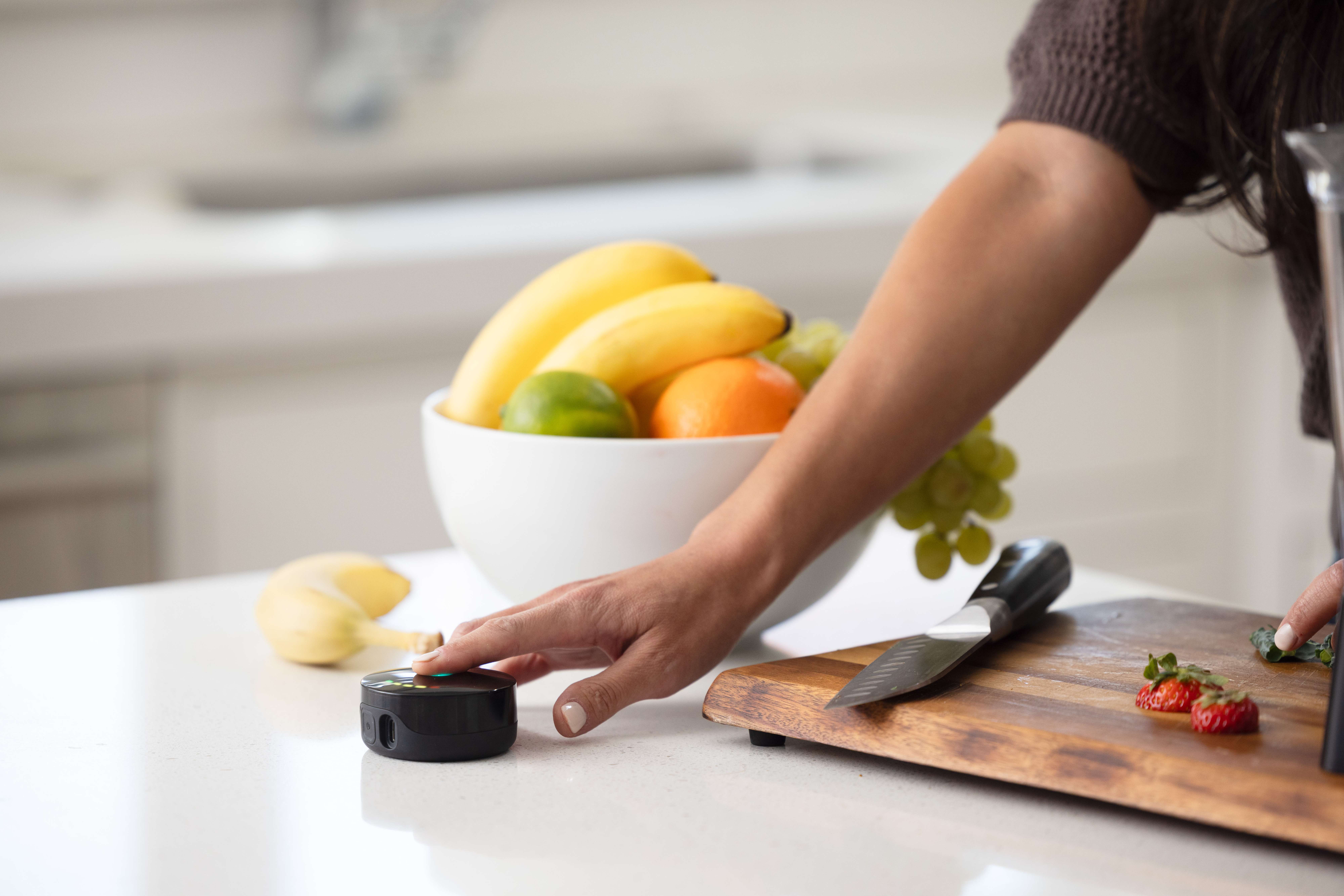 Prysm iO on a kitchen counter near fruit
